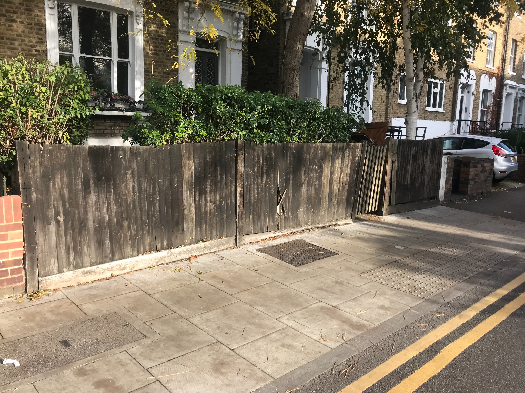 Weathered timber fencing at the same front boundary before replacement.