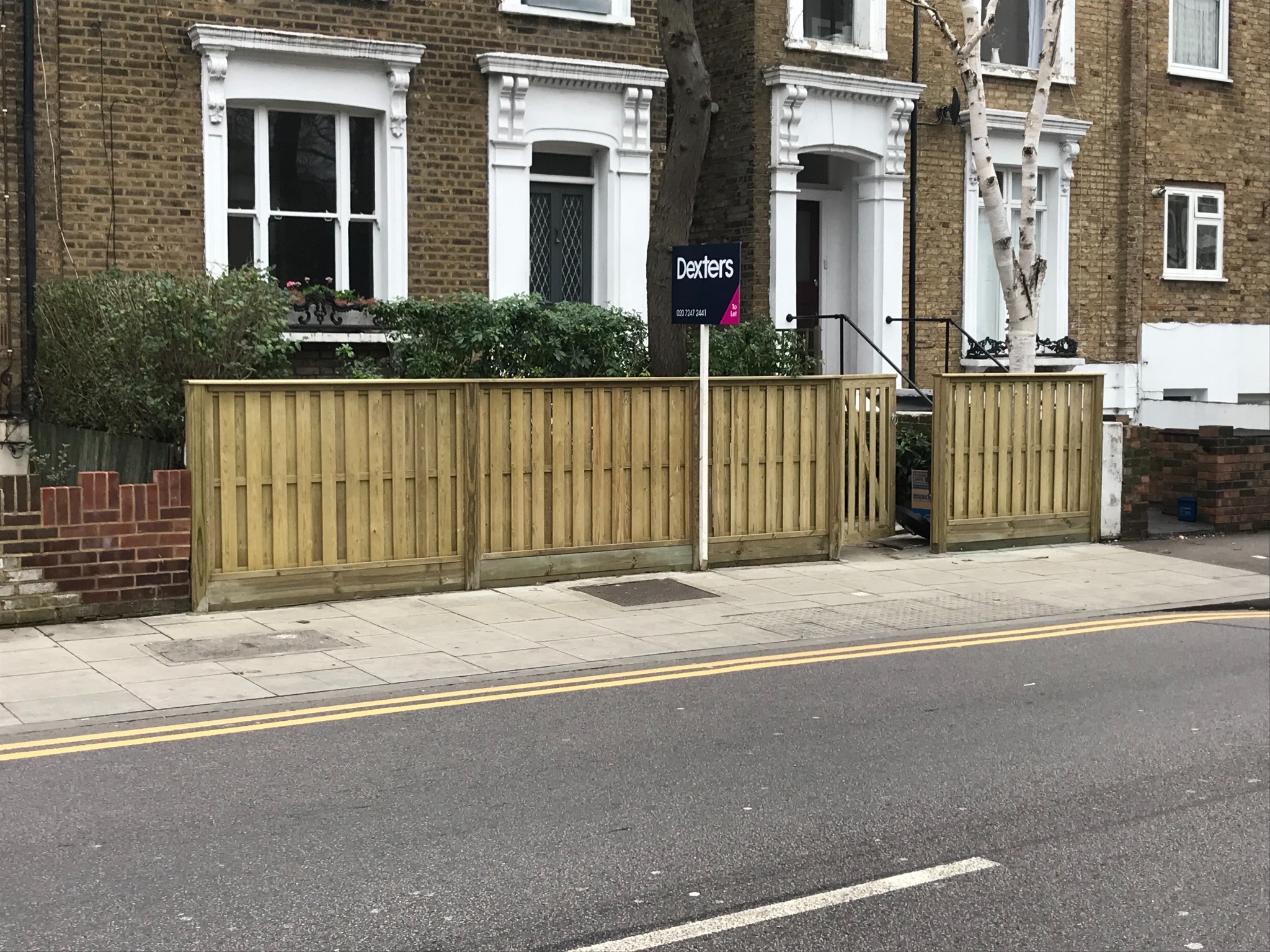 Completed front boundary with vertical timber boards and a matching gate.