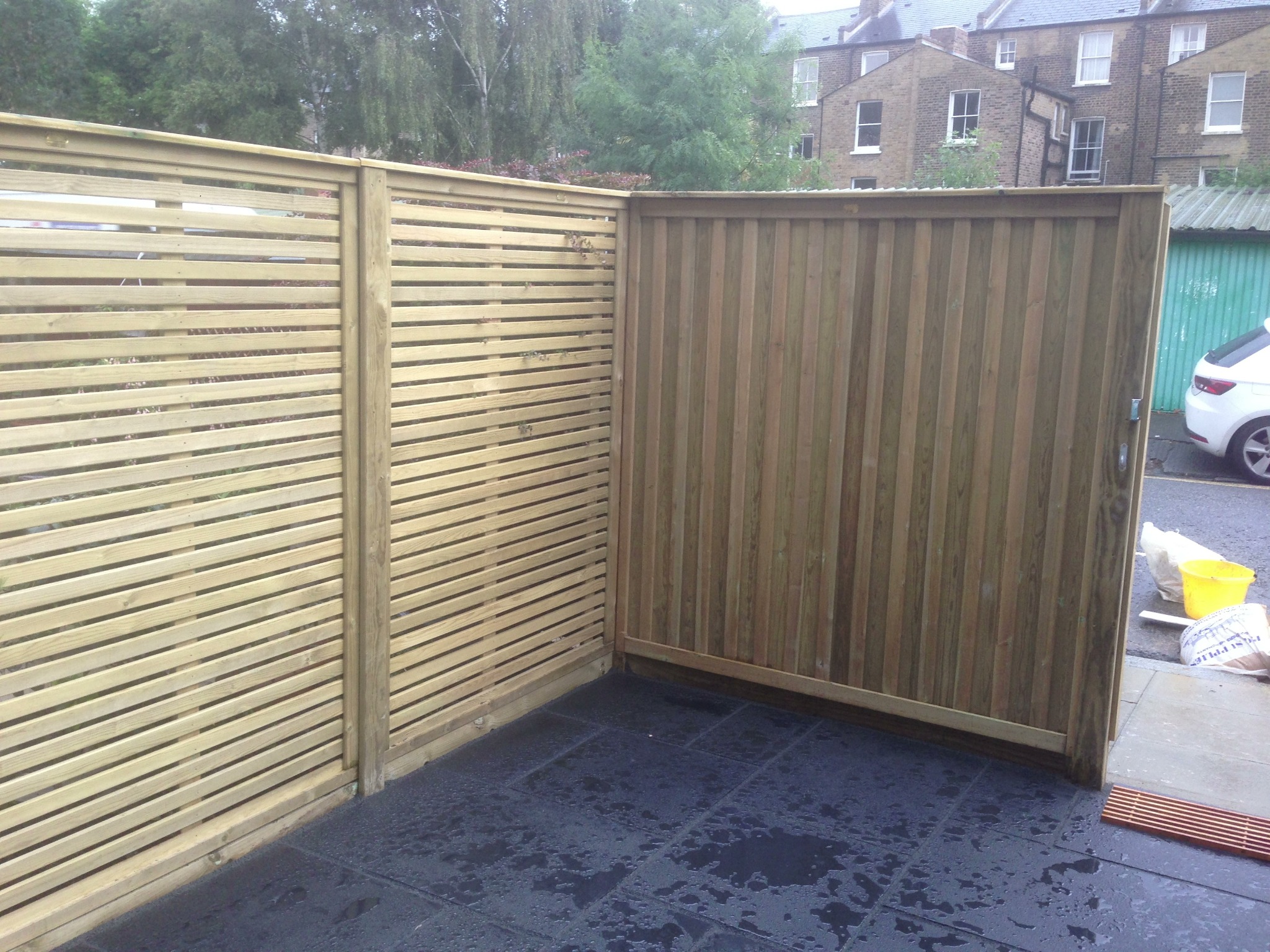 Horizontal timber screening meeting a solid boarded gate.